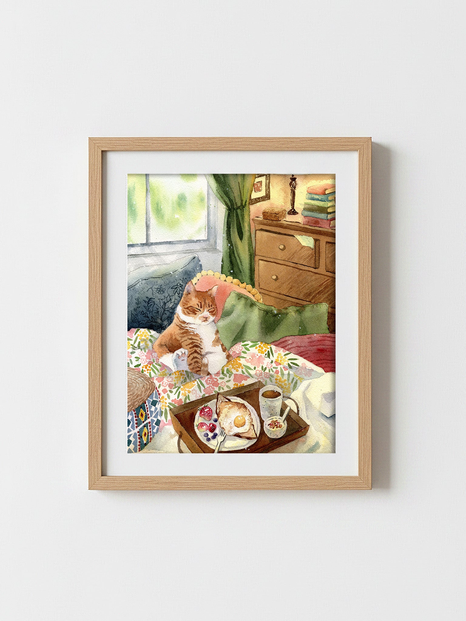Watercolour print of a plump ginger cat napping on cushions beside a breakfast tray