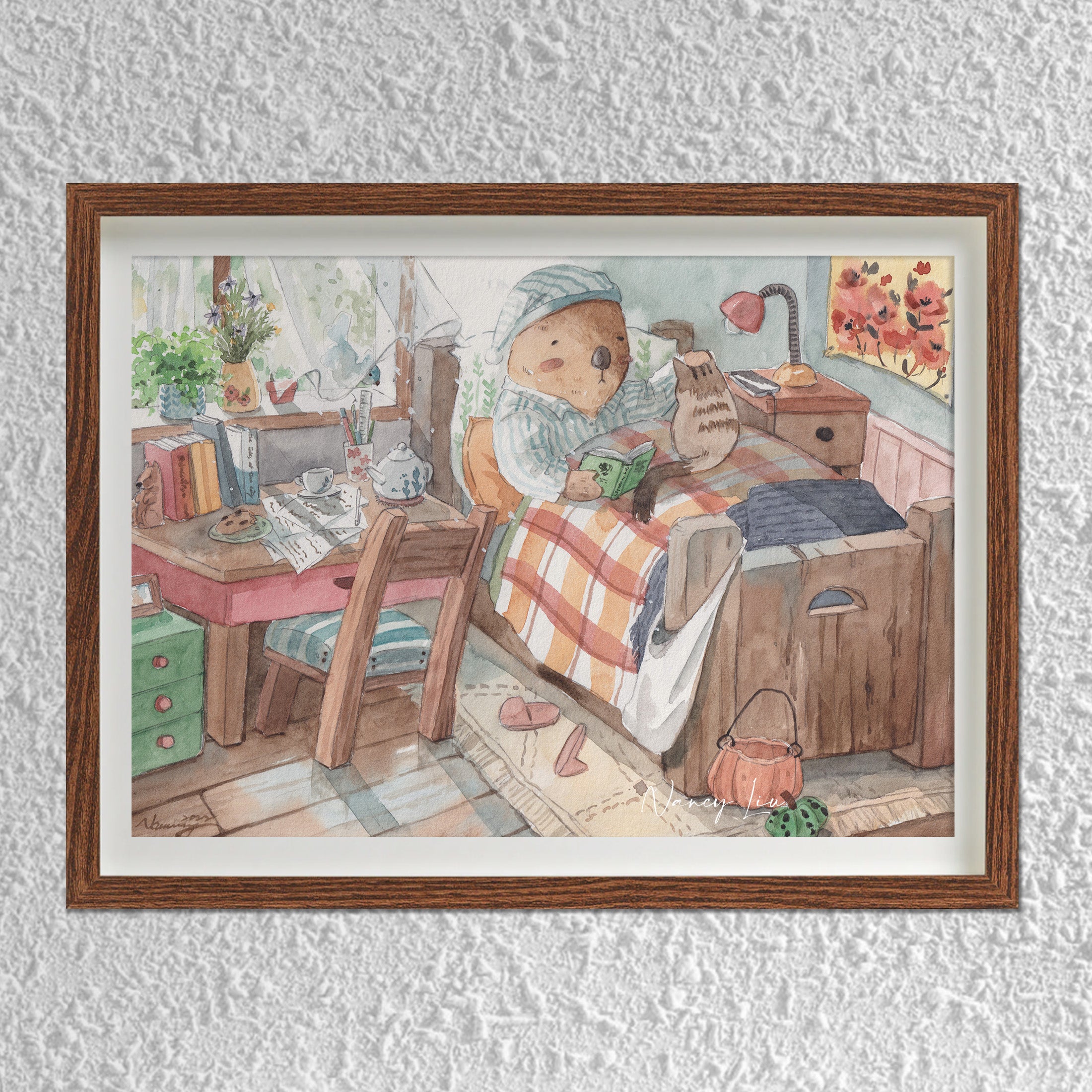 Mr. Otter in bed with kitty print framed on a shelf
