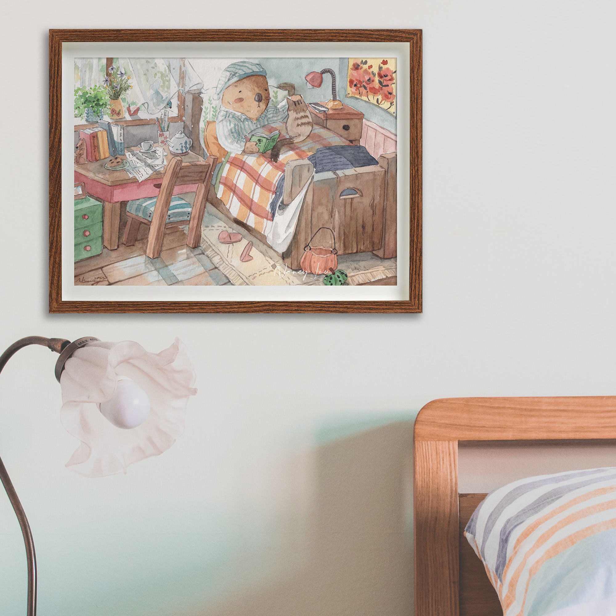 Mr. Otter in bed with kitty print in a frame on a wall