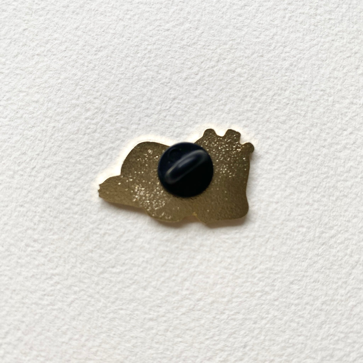 Back of the Principal Bear enamel pin, gold metal with one black rubber pin back
