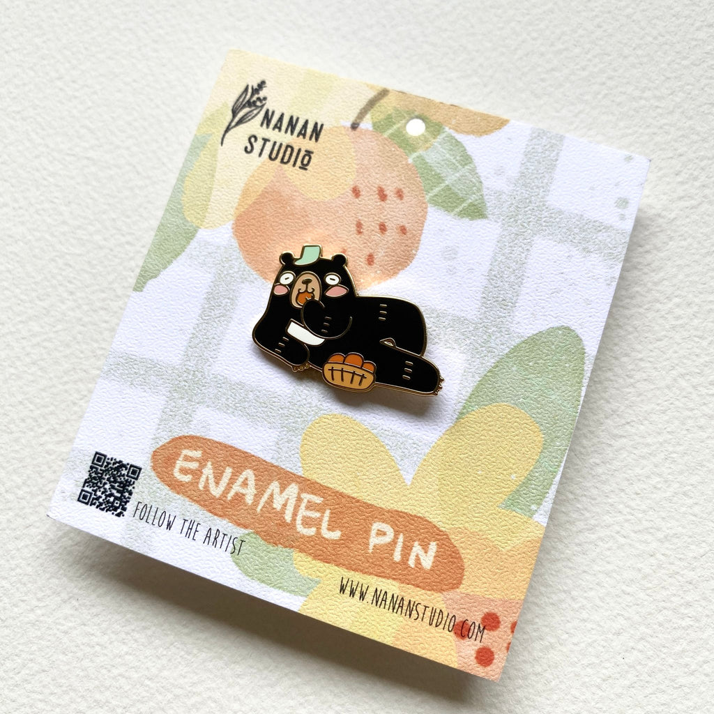 Principal Bear enamel pin on its backing card, tilted to show the Nanan Studio logo and QR code
