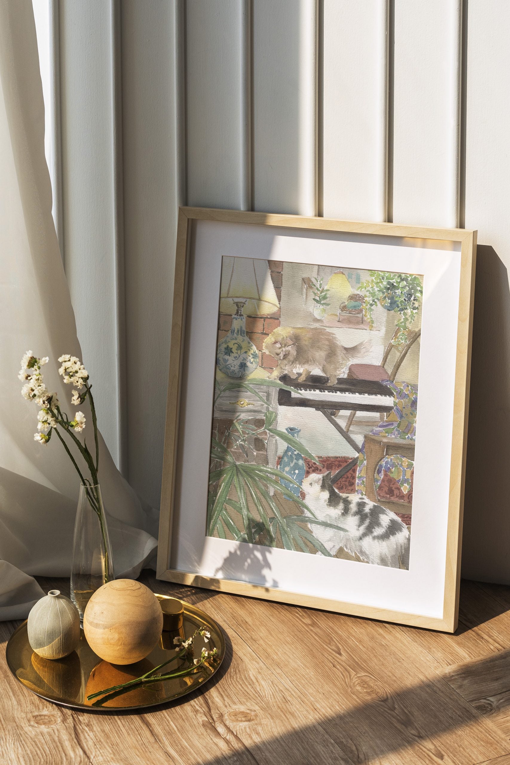 Giclee watercolour print of a ginger cat walking past a piano while another cat watches