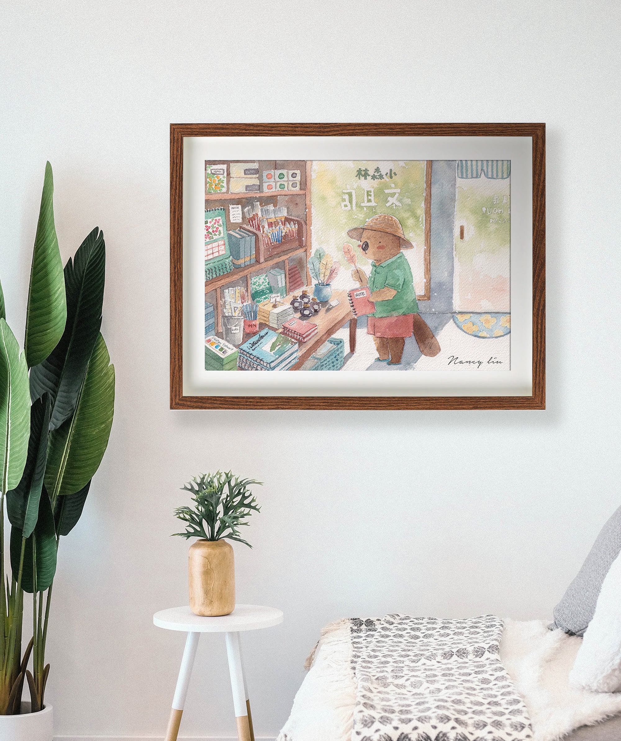 Stationery shop print framed above a desk